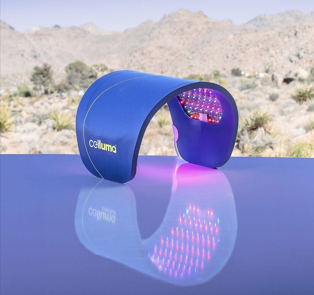 Celluma light therapy device reflecting on a shiny surface with a desert landscape in the background.